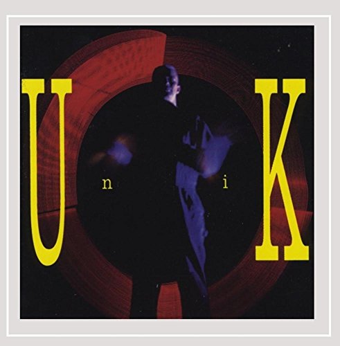 "Album cover with 'Unik' in yellow letters, featuring a man playing guitar."