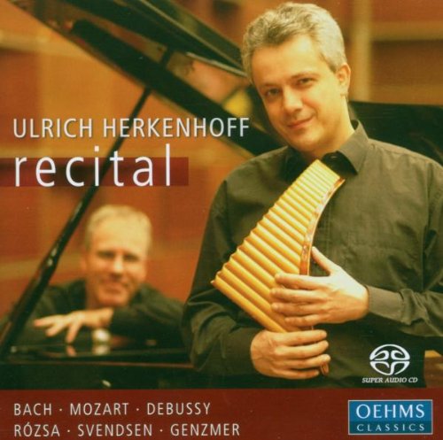 Man holding a melodica, with a pianist in the background, on a CD cover.