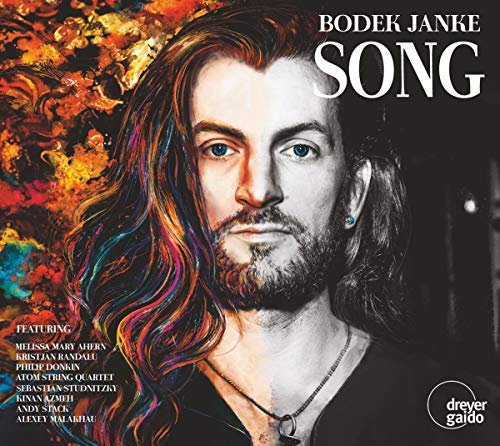 "Album cover with a man having long hair and a necklace, colorful background."