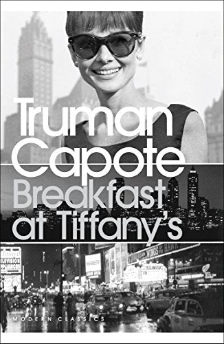 The image shows a book cover for "Breakfast at Tiffany's" by Truman Capote. The alt text is: "Book cover with black and white photo of a croissant and coffee."