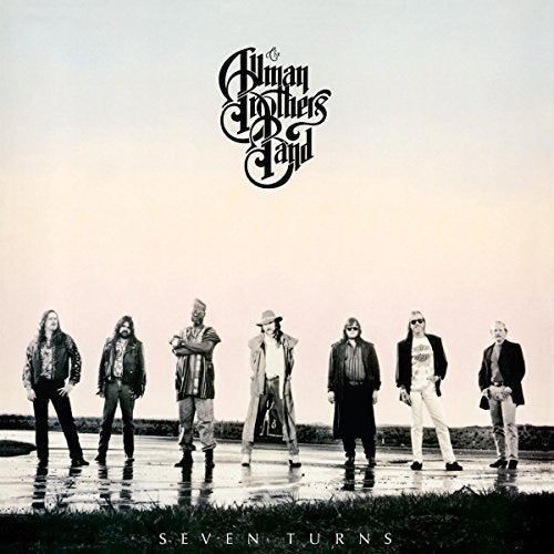 The image shows the album cover for "Seven Turns" by the Allman Brothers Band. Alt text: Black and white photo of seven men standing on a wet surface.