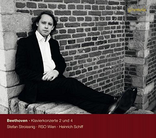 "CD cover with man in black suit sitting against a brick wall."