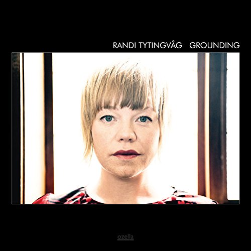 "Album cover featuring a woman with short blonde hair and red plaid shirt."
