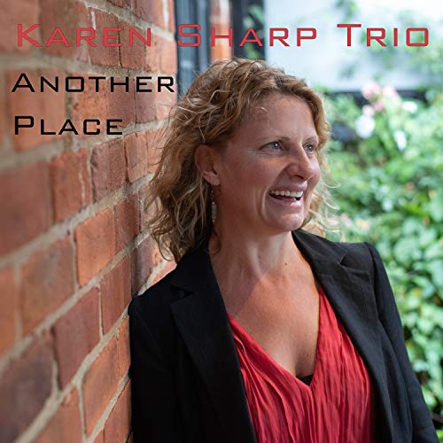 "Album cover featuring a smiling woman in red against a brick wall."