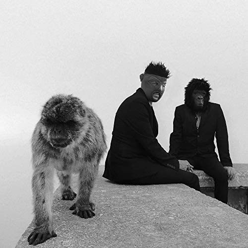 "Black and white album cover featuring two men and a monkey on a concrete surface."