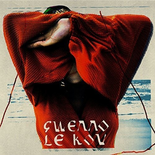 A person with a red blanket over their head, against a blue water background.