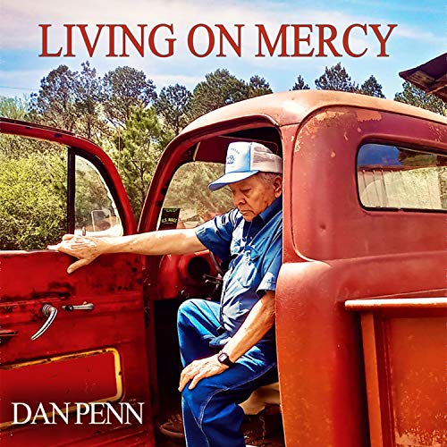 "Album cover: man in blue sitting in red truck, holding a glass."