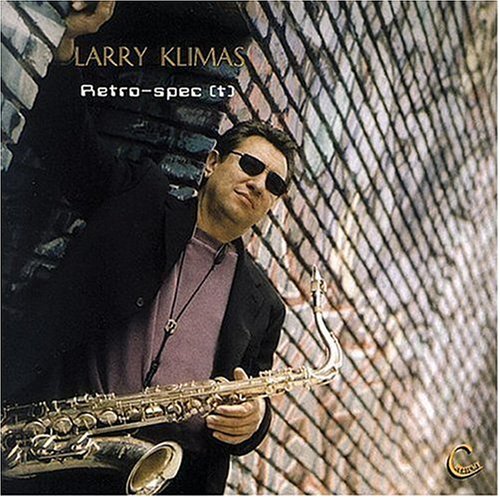 "Album cover with a man holding a saxophone, wearing sunglasses, against a brick wall."