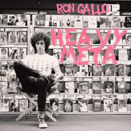 Black and white image of man sitting in front of vinyl records with pink text overlay.