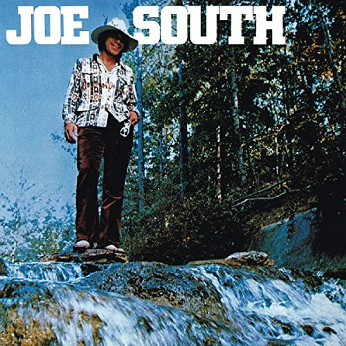 Album cover featuring a man standing on a rock by a waterfall, wearing a cowboy hat.