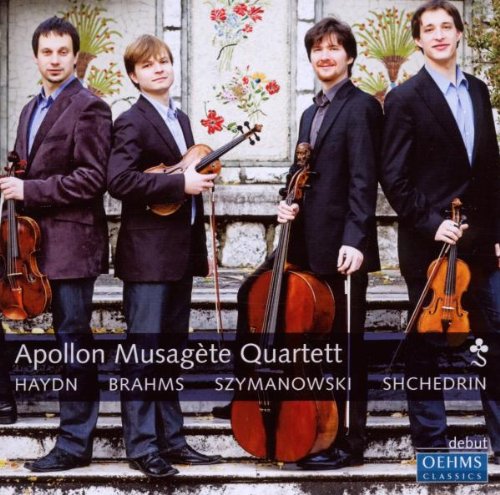 "Four men in suits holding string instruments stand on stone steps with floral decorations."