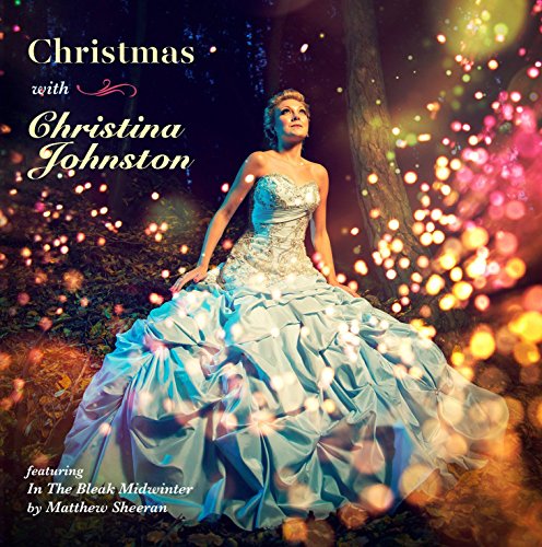 Woman in a white gown sits in a forest surrounded by twinkling lights.