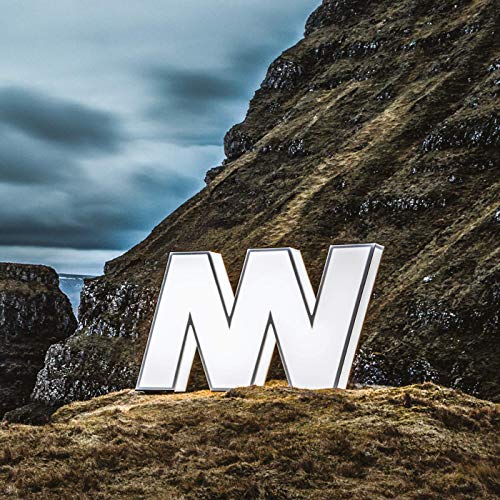 A large white "N" and "W" sculpture on a rocky hill.