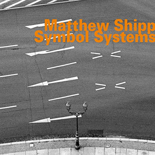 The album cover for "Matthew Shipp - Symbol Systems" features a black-and-white image of a road with white markings and a street lamp.