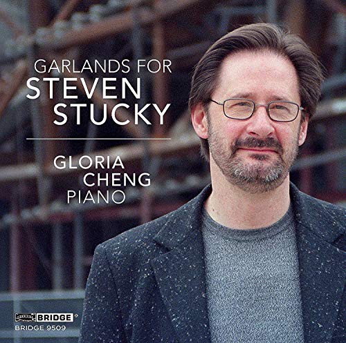 "CD cover featuring a man with glasses and a dark jacket, blurred industrial background."