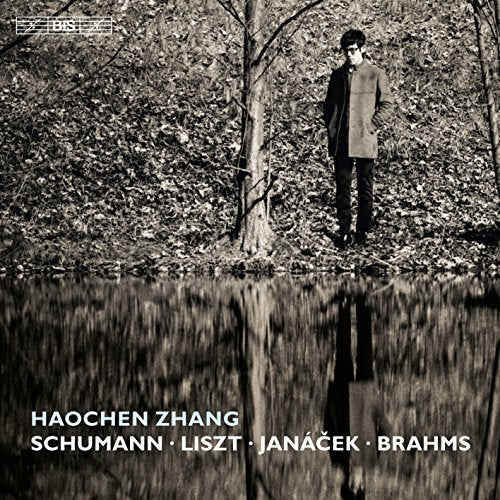 Black-and-white album cover with a man standing by a reflective pond.