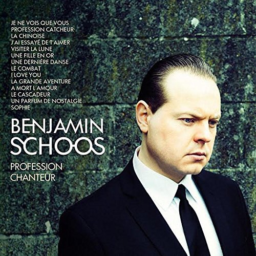 "Album cover featuring a man in a suit against a stone wall background."