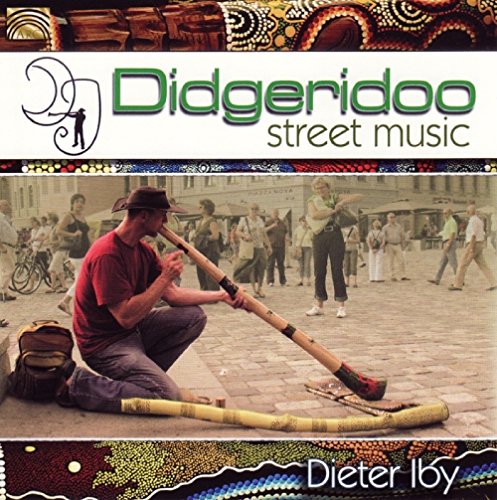 "Album cover featuring a man playing didgeridoo on a street with people walking."