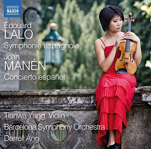 A woman in a red dress holding a violin on a stone wall.