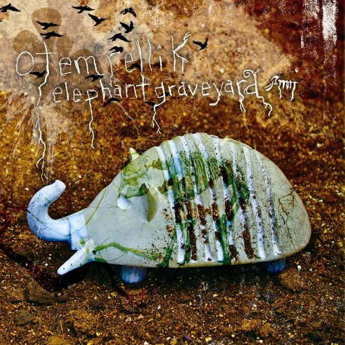 "Album cover featuring a weathered elephant sculpture with birds flying above, on a brown background."