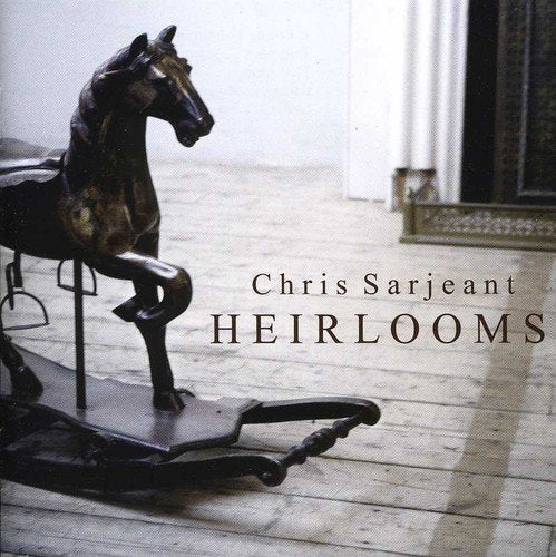 "CD cover featuring a dark wooden rocking horse on a light wooden floor."