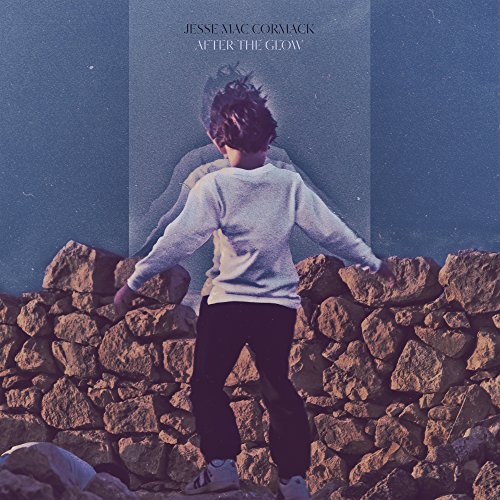 "Album cover featuring a man standing on rocks with a glowing outline."