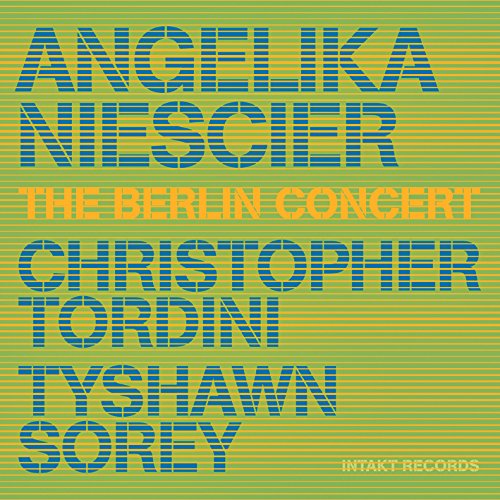 The image depicts a vibrant green and yellow album cover featuring the names of the artists. The cover showcases the names "ANGELIKA NIESCIER", "CHRISTOPHER TORDINI", and "TYSHAWN SOREY" in large, blue, block letters with a striped pattern, arranged in a stacked format. Below the artist names, the text "THE BERLIN CONCERT" is displayed in smaller orange letters. In the bottom-right corner, the label "INTAKT