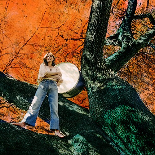 Album cover: woman leaning against a tree holding a drum, orange background.