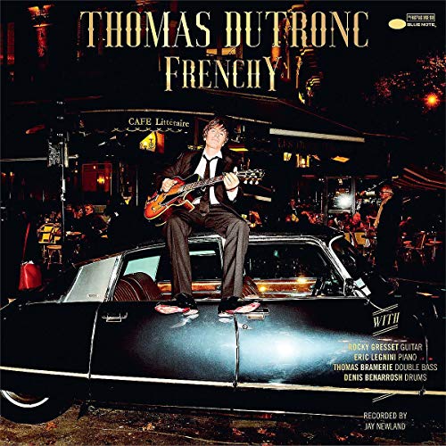 "Album cover featuring Thomas Dutronc sitting on a car, playing guitar."