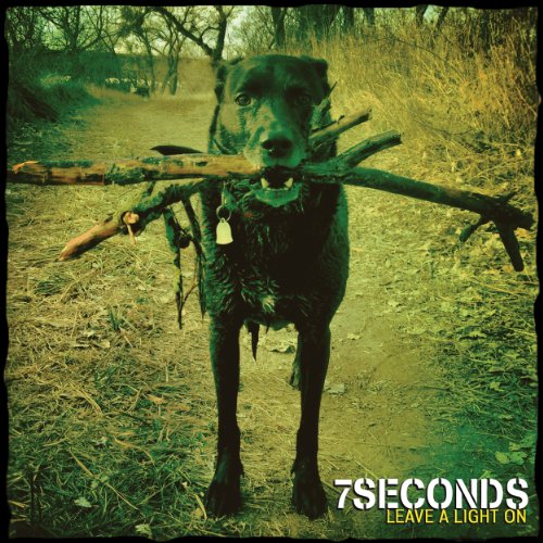 "Album cover featuring a black dog holding a large stick in its mouth."