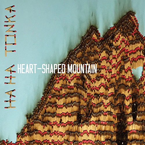 "Album cover featuring a stylized, beaded heart-shaped mountain against a light blue background."