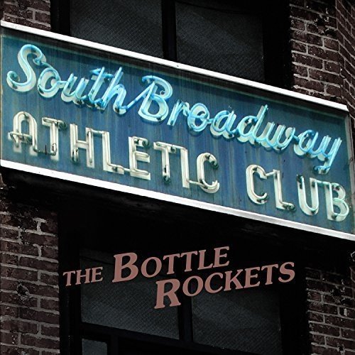 "Neon sign reading 'South Broadway Athletic Club' above a doorway with 'The Bottle Rockets'."