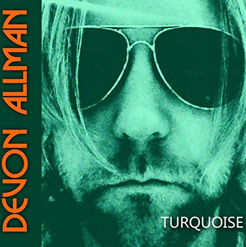 "Album cover with a close-up of a man wearing sunglasses, teal-toned."
