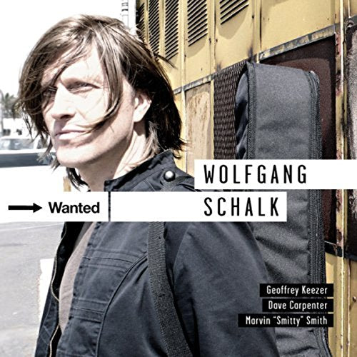 "Wanted" CD cover featuring Wolfgang Schalk with a guitar case and "Wanted" sign.