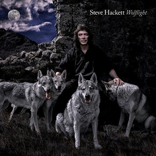 Man kneels with four gray wolves in a rocky, moonlit landscape on album cover.
