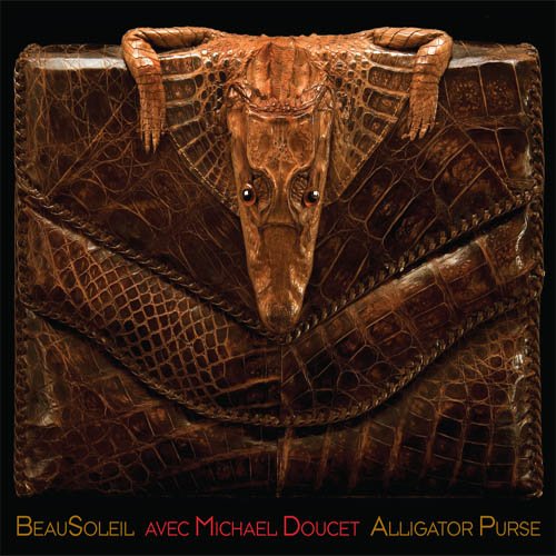 "CD cover featuring a brown alligator skin purse against a black background."