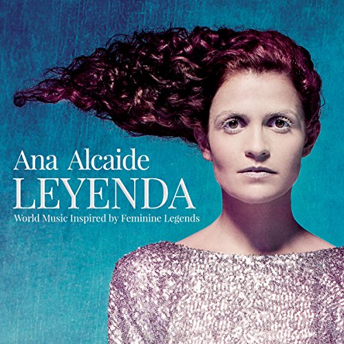 "A woman with curly hair and a sparkly top against a blue background, album cover."