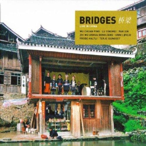 "CD cover with musicians on a wooden balcony over water, traditional Chinese architecture."