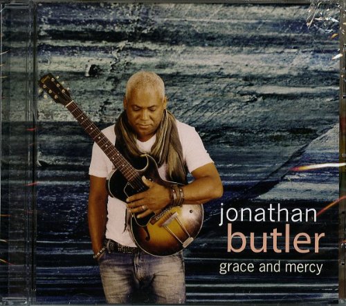 "Album cover featuring Jonathan Butler holding a guitar against a blue wooden background."