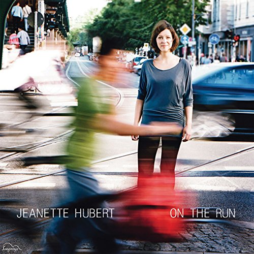 "Album cover with a woman standing on a busy street, blurred motion around her."