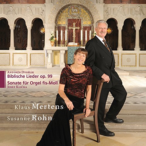 A man and woman in formal attire posing in a church.