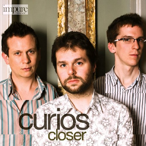 "Three men standing together, wearing patterned shirts, on a music album cover."
