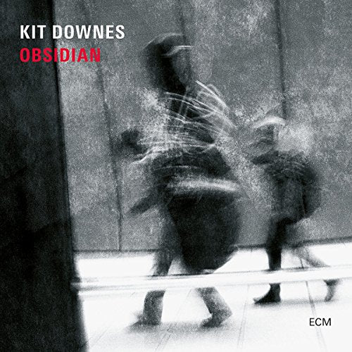"CD cover with blurry black and white image, 'Kit Downes Obsidian' in white and red text."