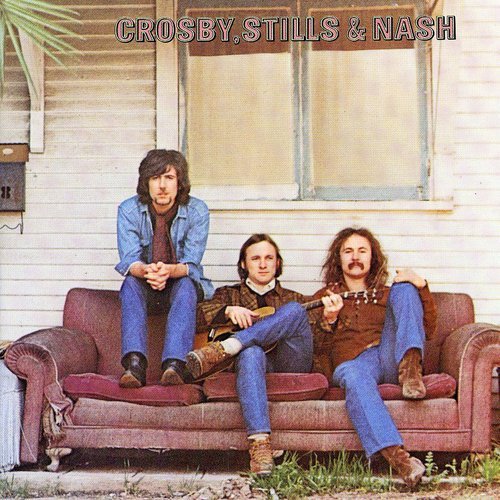 "Album cover featuring three men sitting on a couch outside a house."