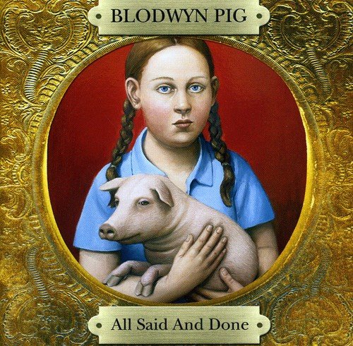 "Album cover featuring a girl holding a pig in an ornate gold frame."