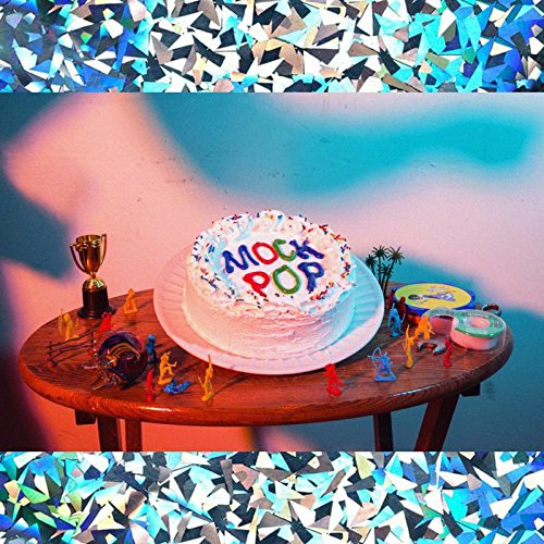 "Album cover with a white cake and 'Mock Pop' text on a wooden table."