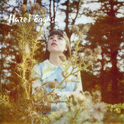 A woman surrounded by tall plants and trees, album cover with "Hazel English" text.