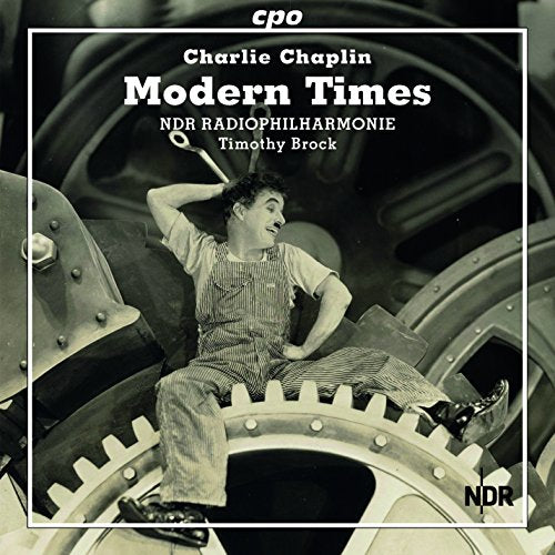 CD cover with Charlie Chaplin sitting on a large gear in black and white.