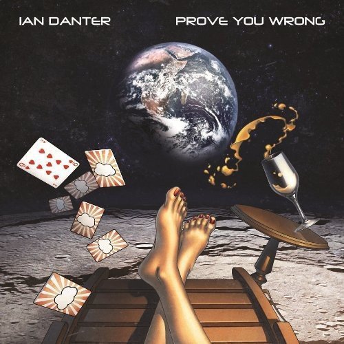 "Album cover with a surreal scene of feet on a lounge chair, cards, and a spilled drink."