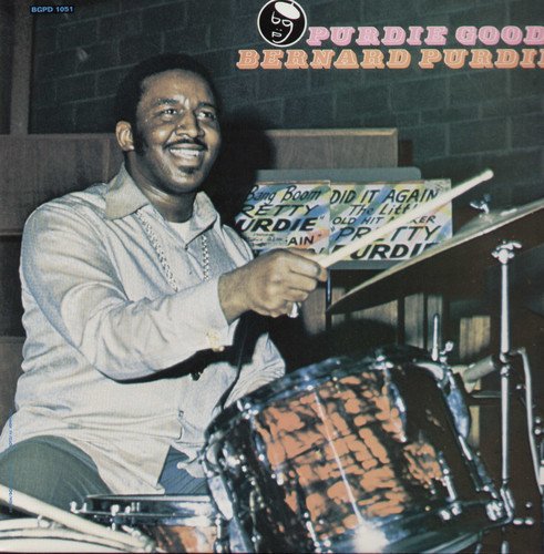 Vinyl album cover featuring a man playing drums with a red and black drum.